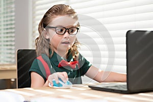 Online remote learning. School kids with computer having video conference chat with teacher in class. Child studying at