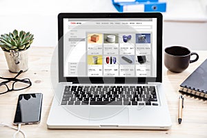Online shop website design template on a computer monitor, office desk background