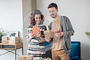 Online shop worker and his coworker examining product package