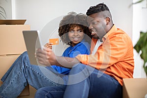 Online Shopping. Black Smiling Couple Using Digital Tablet And Credit Card