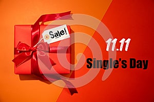 Online shopping of China, 11.11 single`s day sale concept. Top view of christmas boxes with red ribbon on red and orange