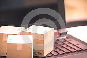 Online shopping concept e-commerce delivery buying service. square cartons shopping on laptop keyboard, showing customer order vi