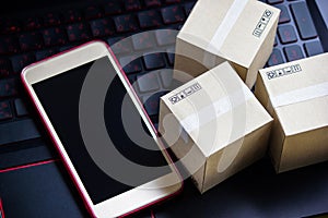 Online shopping concept e-commerce delivery buying service. square cartons shopping on laptop keyboard, showing customer order vi