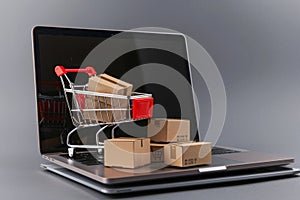 Online shopping concept with laptop and full cart for e-commerce and internet retailing photo