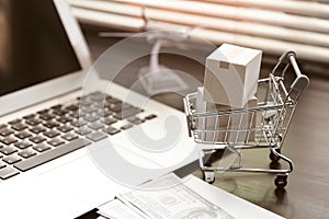 Online shopping concept. paper boxes in shopping cart on  Laptop Computer at home office