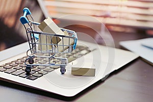 Online shopping concept. paper boxes in shopping cart on  Laptop Computer at home or office