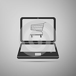 Online shopping concept. Shopping cart on screen laptop icon isolated on grey background. Concept e-commerce, e-business