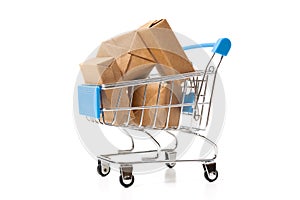 Online shopping concept. Shopping cart with small boxes inside on white background