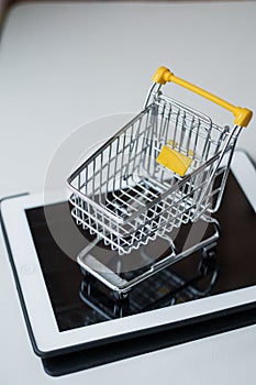 Online shopping concept. Shopping cart, small boxes photo