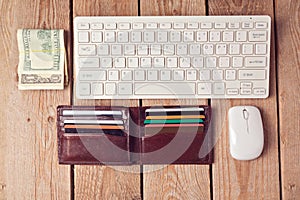 Online shopping concept with wallet, money and keyboard on wooden background