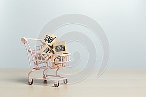 Online shopping concept. Wooden cubes block with business icons in shopping cart, sell marketing purchase delivery