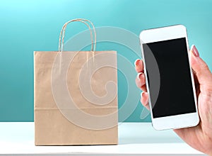 Online shopping,e-commerce.Bag and phone screen in hand.Internet shop online order