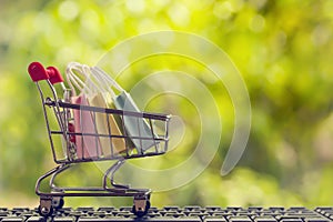 Online shopping, e-commerce concept: Paper shopping bags in a trolley or shopping cart  in the natural green background. purchase