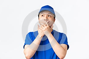 Online shopping, fast shipping, employees and home delivery concept. Close-up of shocked and astounded asian male