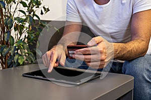 online shopping man paying order online with tablet and credit card from home