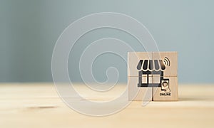 Online shopping and online marketing concept. The wooden cubes with shop and online purchasing icons on grey background and copy s