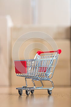 Concept of online shopping: Little shopping cart on delivery boxes