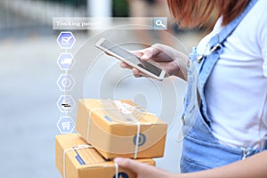 Online shopping, Woman hand holding smart phone and tracking parcel online to update status with hologram, Ecommerce and delivery