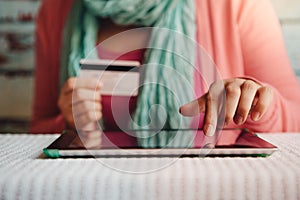 Online shopping - young woman with credit card in hand paying or booking in internet shop