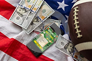 Online sports betting. Dollars are falling on the background of a hand with a smartphone and a soccer ball. Creative