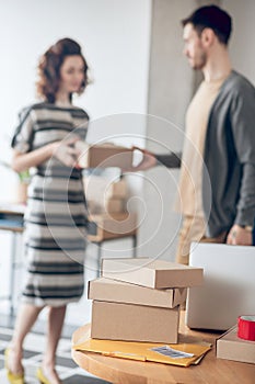 Online store worker handing over a package to a courier