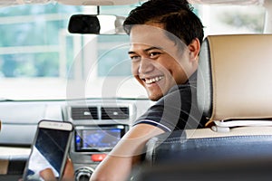 Online taxi driver, transportation, travelling concept - smilling while the costumer showing smartphone screen for paying and give