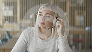 Online technical support worker. Blonde woman with headphones on head