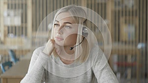 Online technical support worker. Blonde woman with headphones on head