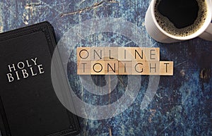 Online Tonight Written in Block Letters on a Blue Wood Table with a Bible