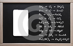 . Online training, chemistry. Tablet on the background of a class board with written chemistry formulas