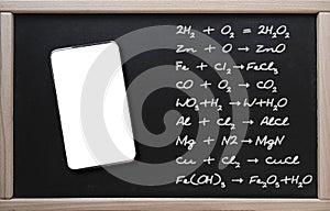 . Online training, chemistry. Tablet on the background of a class board with written chemistry formulas