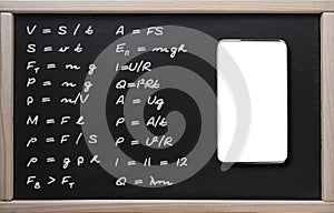 . Online training, physics lessons. A tablet on the background of a class board with written formulas in physics