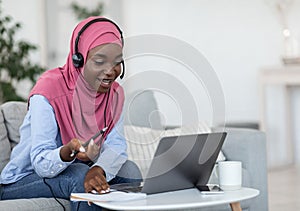 Online Tutoring. Friendly black muslim female tutor having video call with students