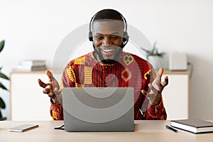 Online Tutoring. Male African Teacher In Headset Having Web Lesson With Laptop photo