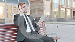 Online Video Chat on Tablet by Businessman Sitting Outdoor on Bench