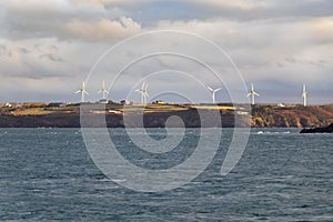 Onshore wind turbines on the French coast village, sustainable wind energy in Brittany, France