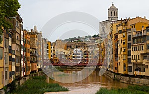 The Onyar river flanked by the city of Girona and crossed by an Eiffel bridge.