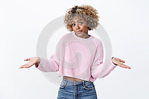 Oops did not know. Cute silly african-american girlfriend with blond haircut making innocent and unaware look shrugging