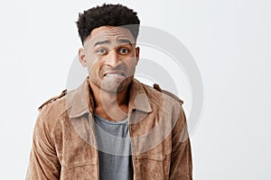 Oops. Portrait of unhappy young good-looking afro american men with curly hair in casual stylish clothes looking at