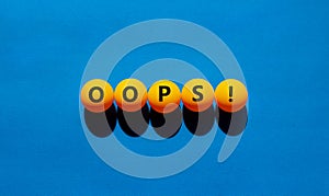 Oops symbol. Orange table tennis balls with the words `oops`. Beautiful blue background, copy space. Warm sunshine. Business and