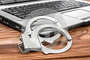 Op with handcuffs on the table. Cybercrime concept