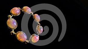 Opal brooch luminescent against black background