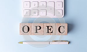 OPEC on wooden cubes with pen and calculator, financial concept