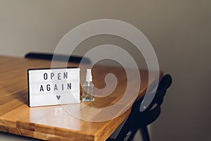 Open again sigh on wooden table. local business reopen after quarantine covid-19