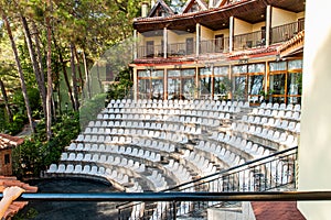 Open-air amphitheater for evening performances at a coastal hotel, surrounded by lush vegetation