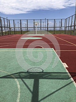 An open air basketball court in a sunny day