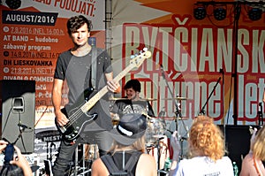 Open air concert of rock music band called The Paranoid. Guitarist stand in forefront, drummer plays back.