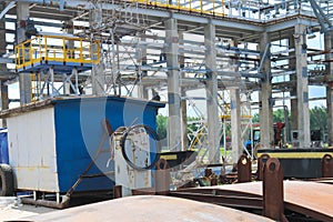 An open-air production site at an industrial plant, a workshop for welding large iron metal barrels and containers made of metal