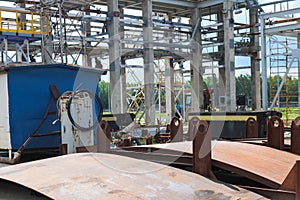 An open-air production site at an industrial plant, a workshop for welding large iron metal barrels and containers made of metal