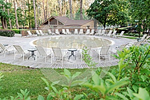 An open-air round artificial pond. Sun beds and tables for rest near the round pool. Relax and spa concept